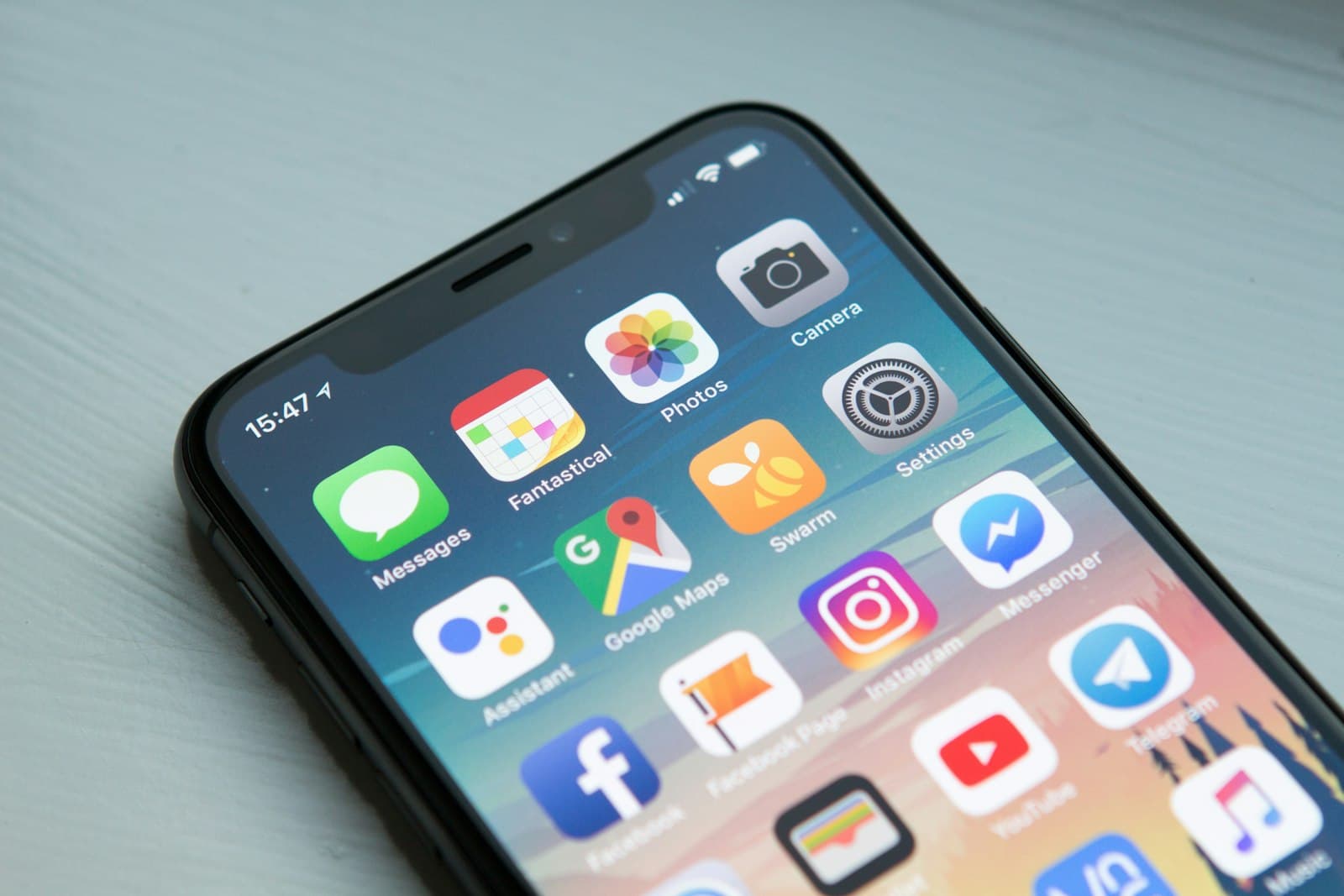 A hand holding a smartphone with finance apps on screen